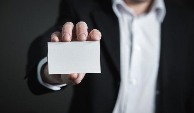 Image of a businessman holding a blank business card - he still needs a business name.
